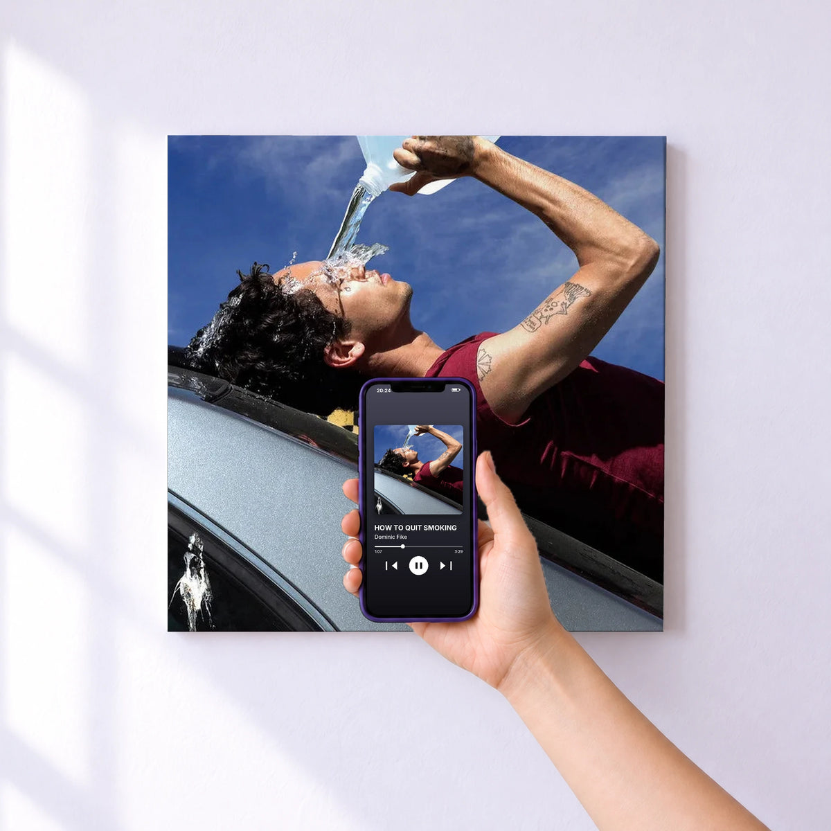 Affiche connectée HOW TO QUIT SMOKING de Dominic Fike au mur : l'album se lance en approchant le téléphone