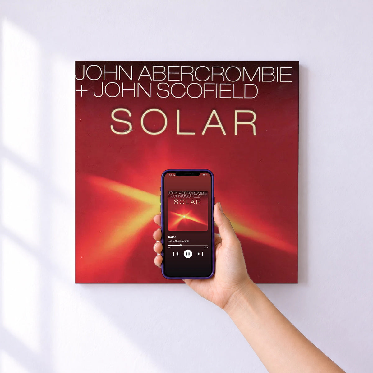Affiche connectée Solar de John Abercrombie au mur : l'album se lance en approchant le téléphone