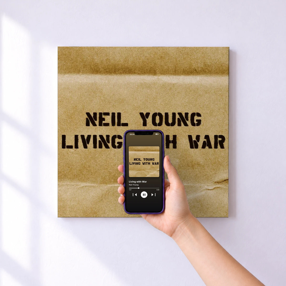 Affiche connectée Living with War de Neil Young au mur : l'album se lance en approchant le téléphone