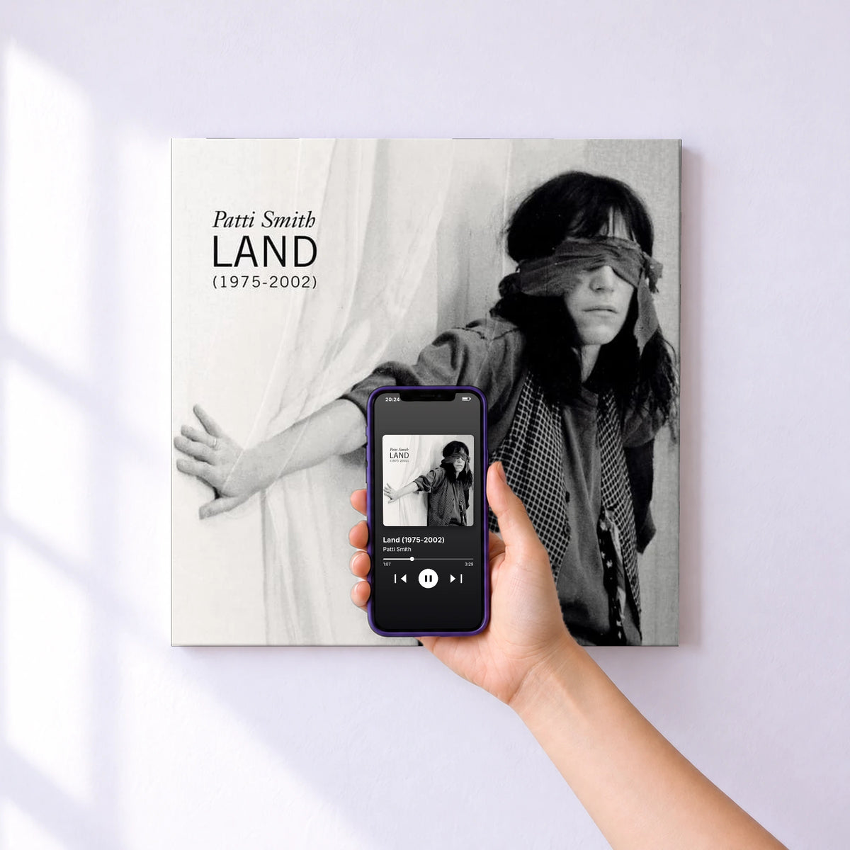 Affiche connectée Land (1975-2002) de Patti Smith au mur : l'album se lance en approchant le téléphone