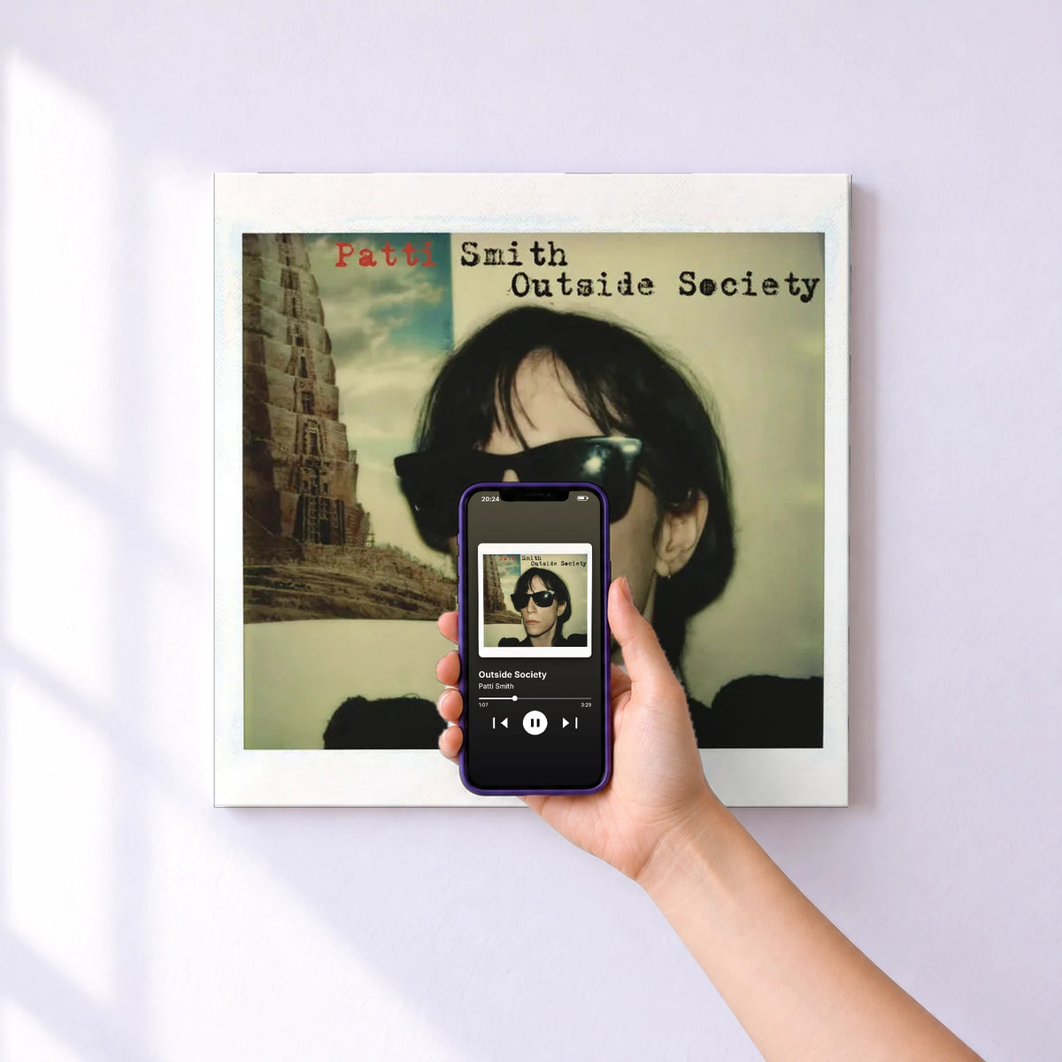 Affiche connectée Outside Society de Patti Smith au mur : l'album se lance en approchant le téléphone