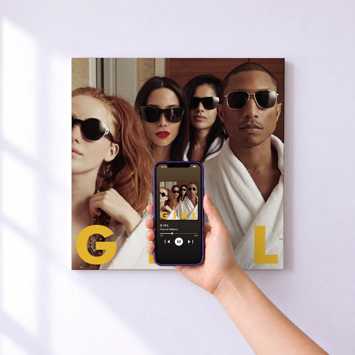 Affiche connectée G I R L de Pharrell Williams au mur : l'album se lance en approchant le téléphone
