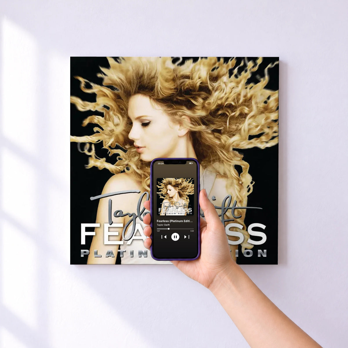 Affiche connectée Fearless (Platinum Edition) de Taylor Swift au mur : l'album se lance en approchant le téléphone