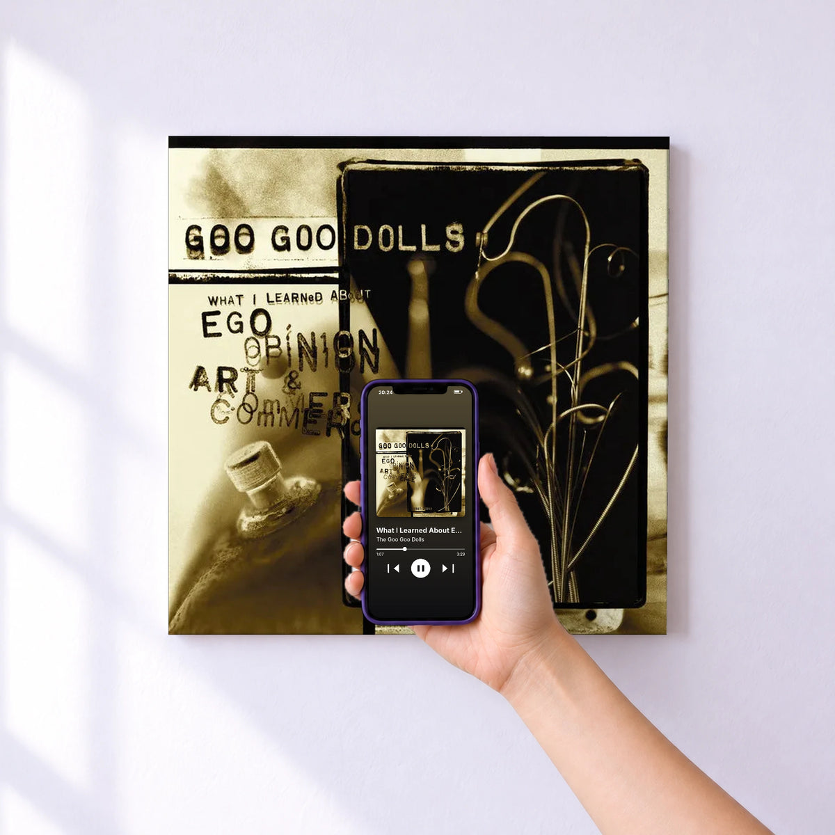 Affiche connectée What I Learned About Ego, Opinion, Art & Commerce (1987-2000) de The Goo Goo Dolls au mur : l'album se lance en approchant le téléphone