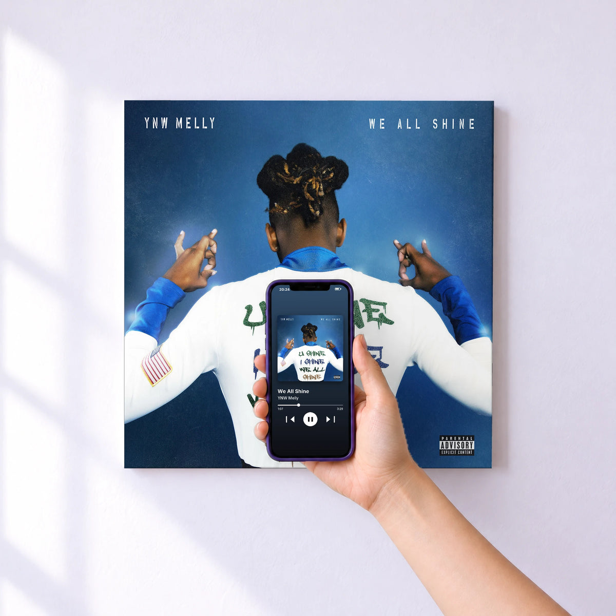 Affiche connectée We All Shine de YNW Melly au mur : l'album se lance en approchant le téléphone