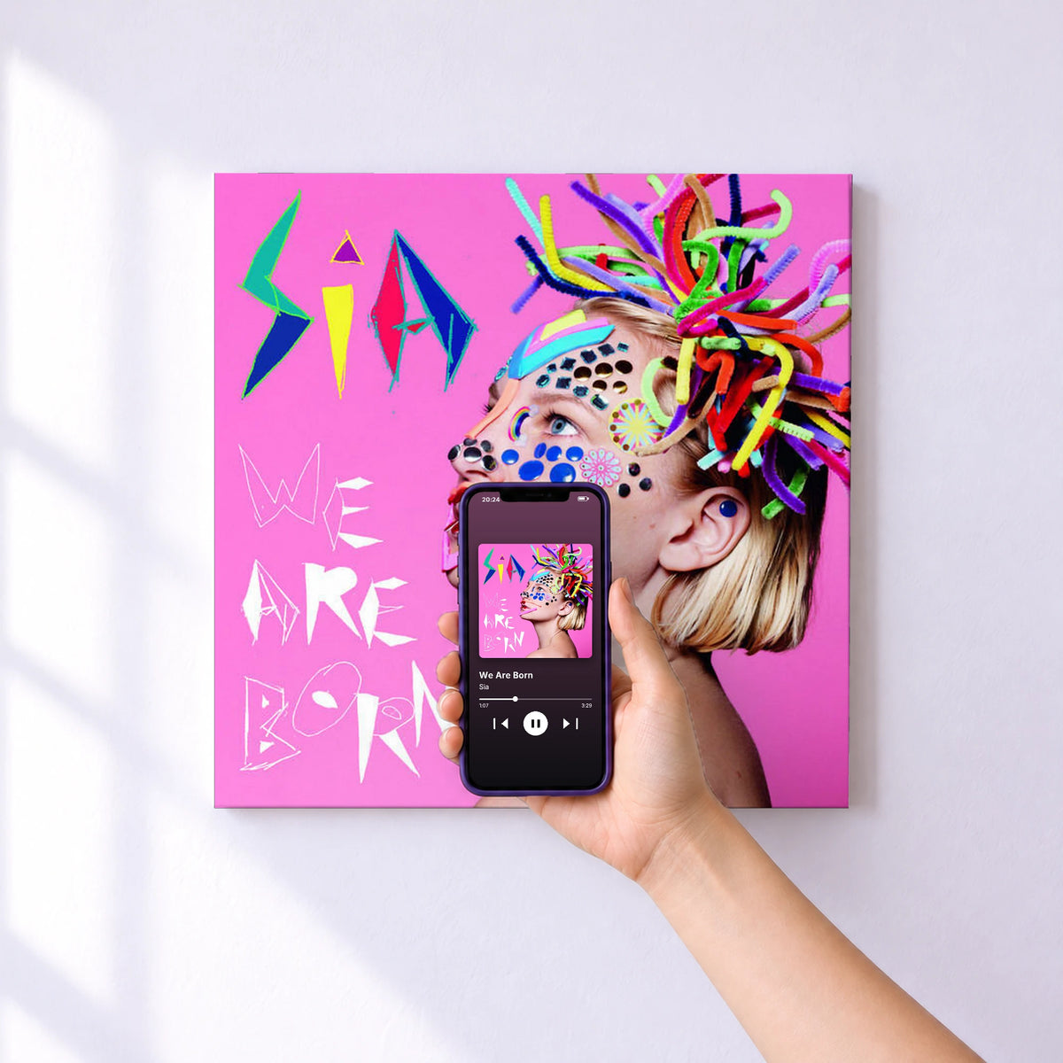 Affiche connectée We Are Born de Sia au mur : l'album se lance en approchant le téléphone