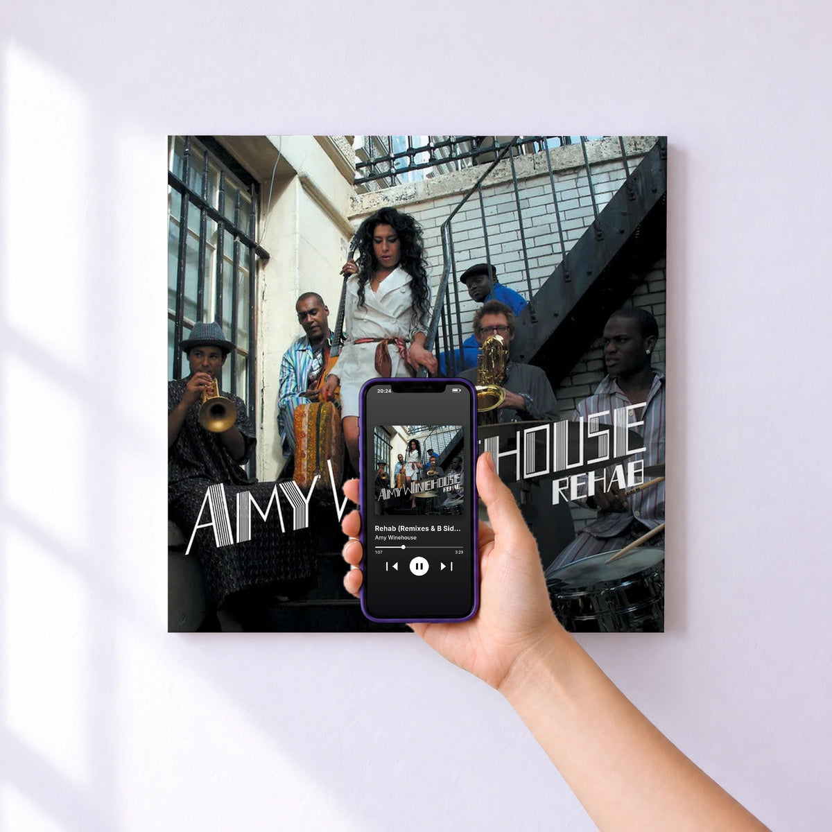Affiche connectée Rehab (Remixes & B Sides) de Amy Winehouse au mur : l'album se lance en approchant le téléphone