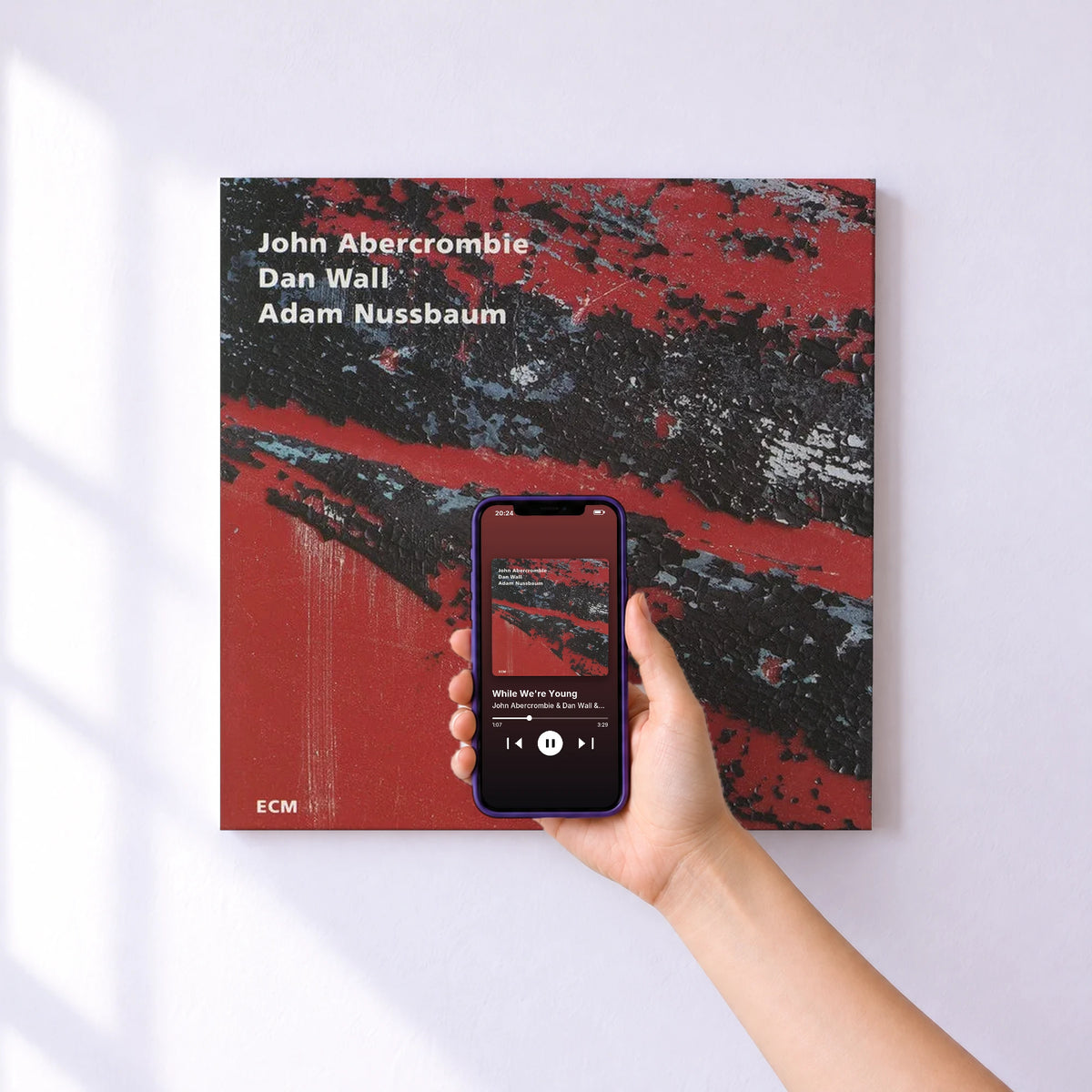 Affiche connectée While We're Young de John Abercrombie & Dan Wall & Adam Nussbaum au mur : l'album se lance en approchant le téléphone