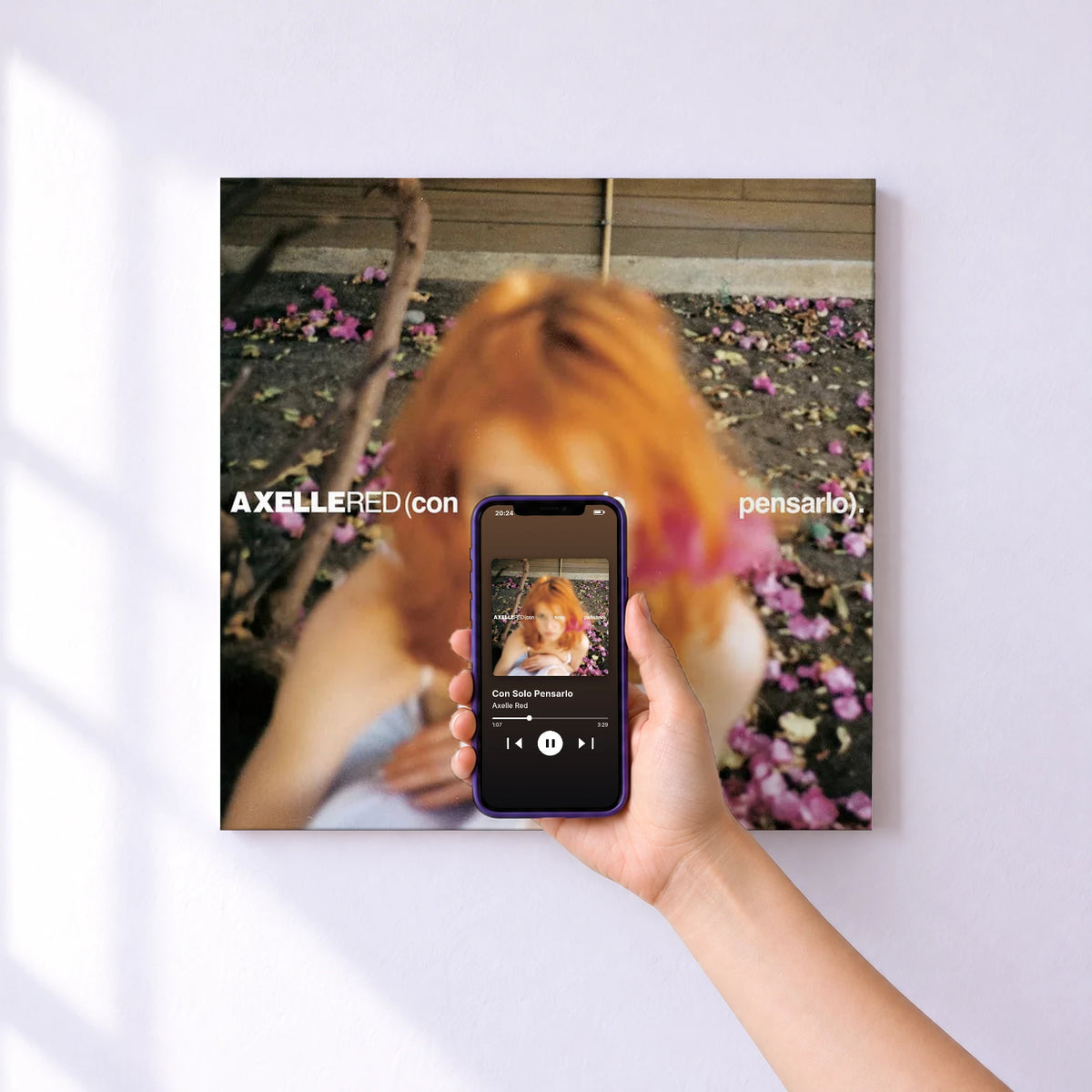 Affiche connectée Con Solo Pensarlo de Axelle Red au mur : l'album se lance en approchant le téléphone