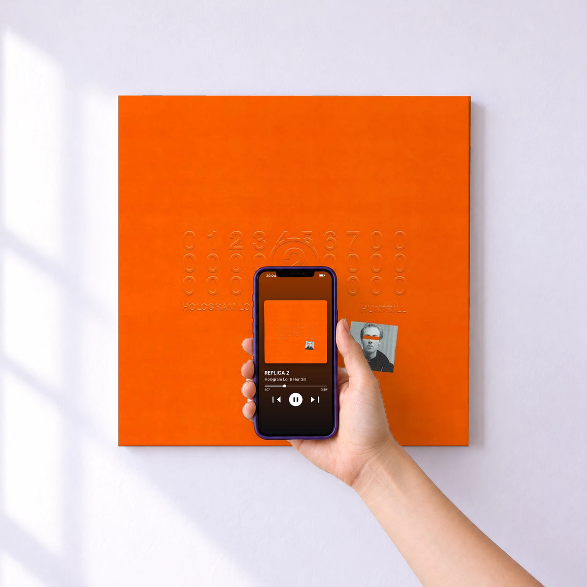Affiche connectée REPLICA 2 de Hologram Lo' & Huntrill au mur : l'album se lance en approchant le téléphone