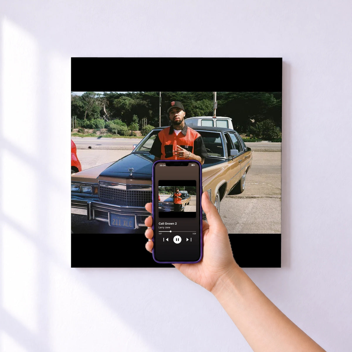 Affiche connectée Cali Grown 2 de Larry June au mur : l'album se lance en approchant le téléphone
