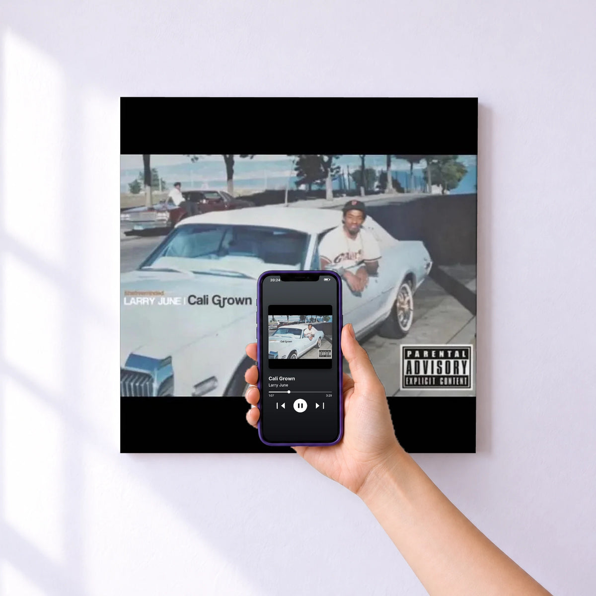 Affiche connectée Cali Grown de Larry June au mur : l'album se lance en approchant le téléphone