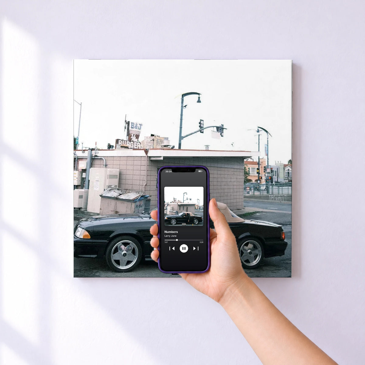 Affiche connectée Numbers de Larry June au mur : l'album se lance en approchant le téléphone