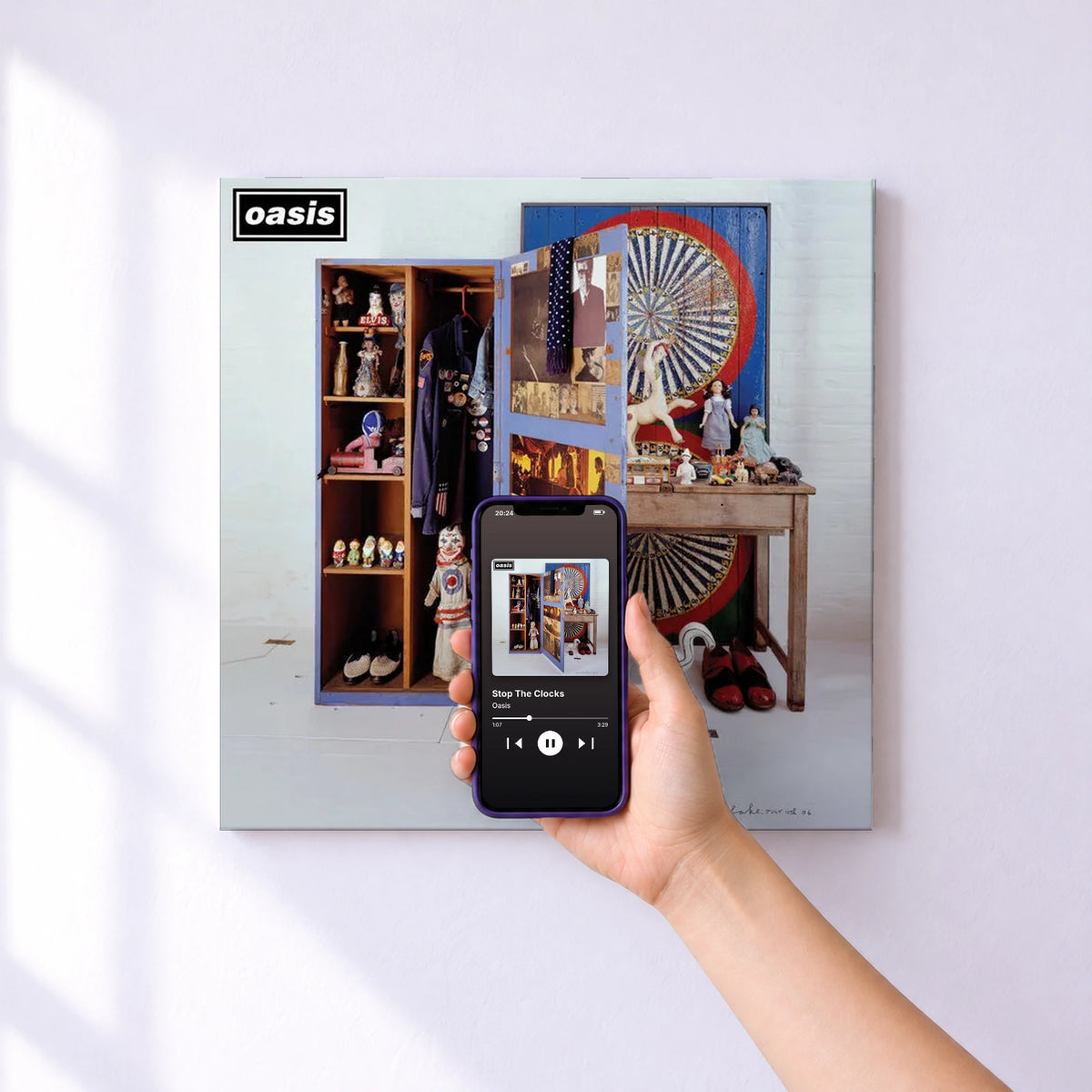 Affiche connectée Stop The Clocks de Oasis au mur : l'album se lance en approchant le téléphone