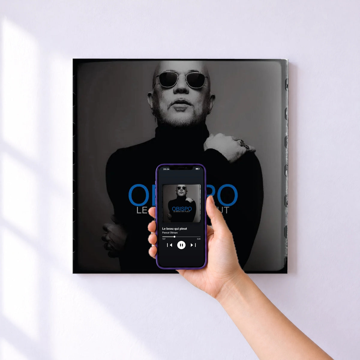 Affiche connectée Le beau qui pleut de Pascal Obispo au mur : l'album se lance en approchant le téléphone