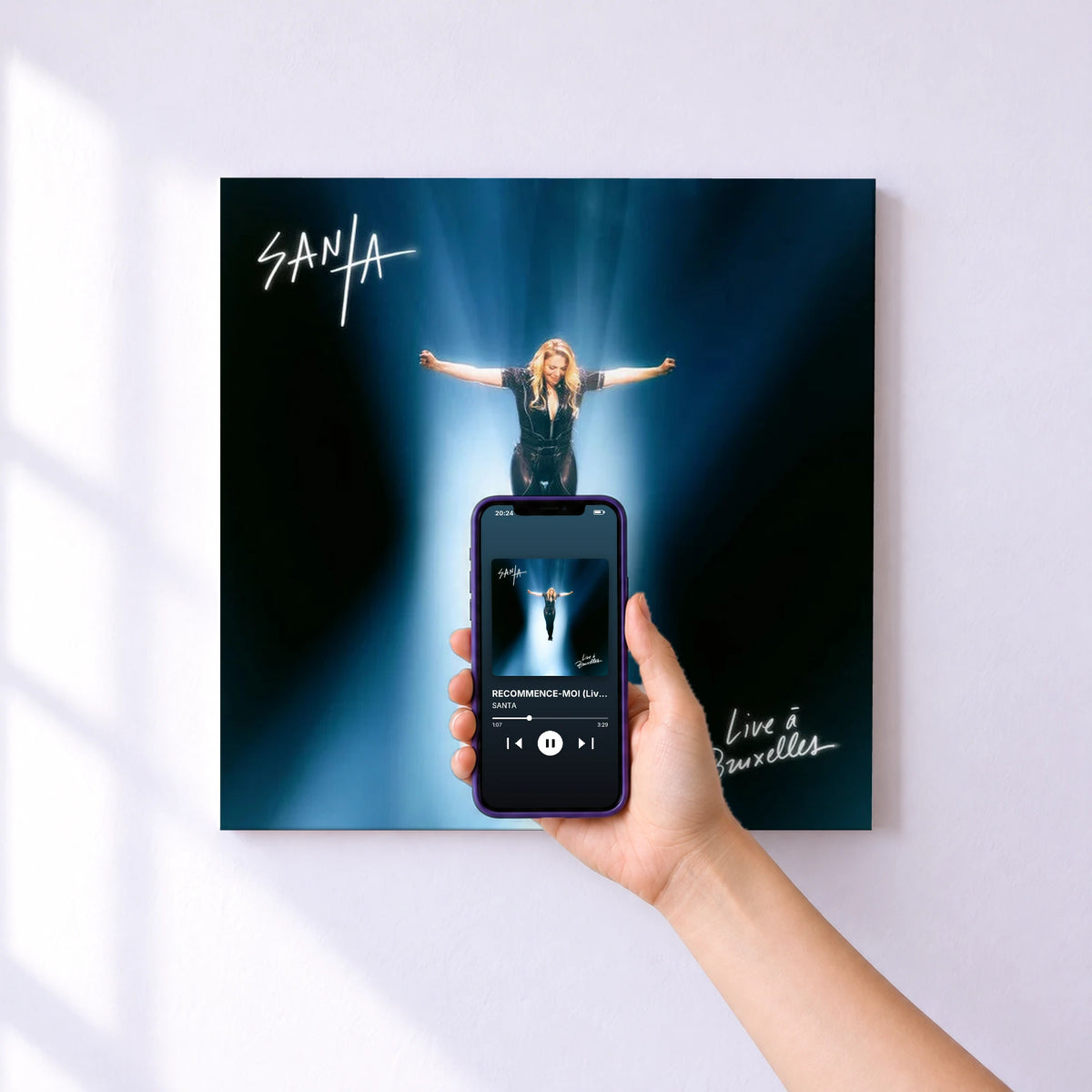 Affiche connectée RECOMMENCE-MOI (Live à Bruxelles 2026) de SANTA au mur : l'album se lance en approchant le téléphone
