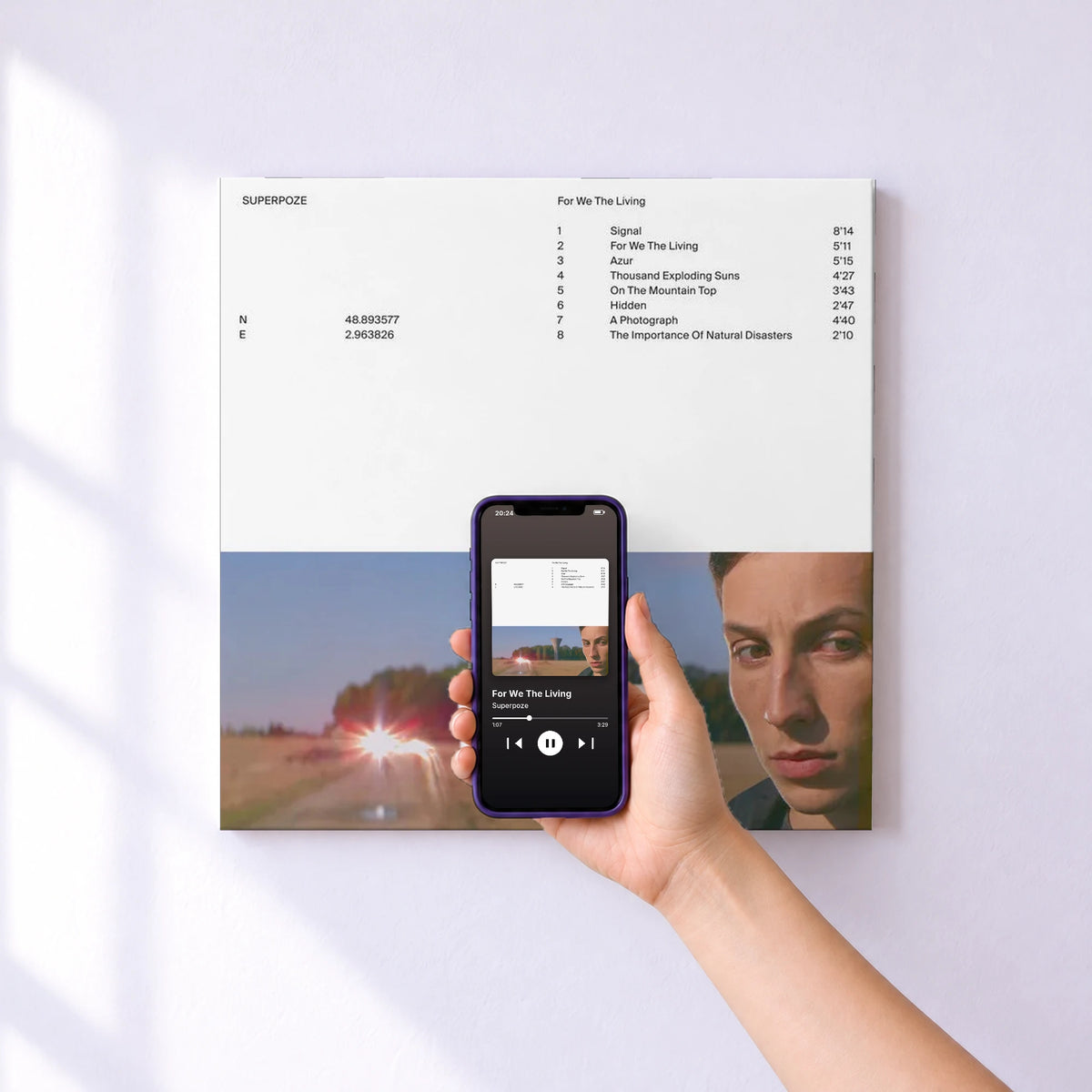 Affiche connectée For We The Living de Superpoze au mur : l'album se lance en approchant le téléphone