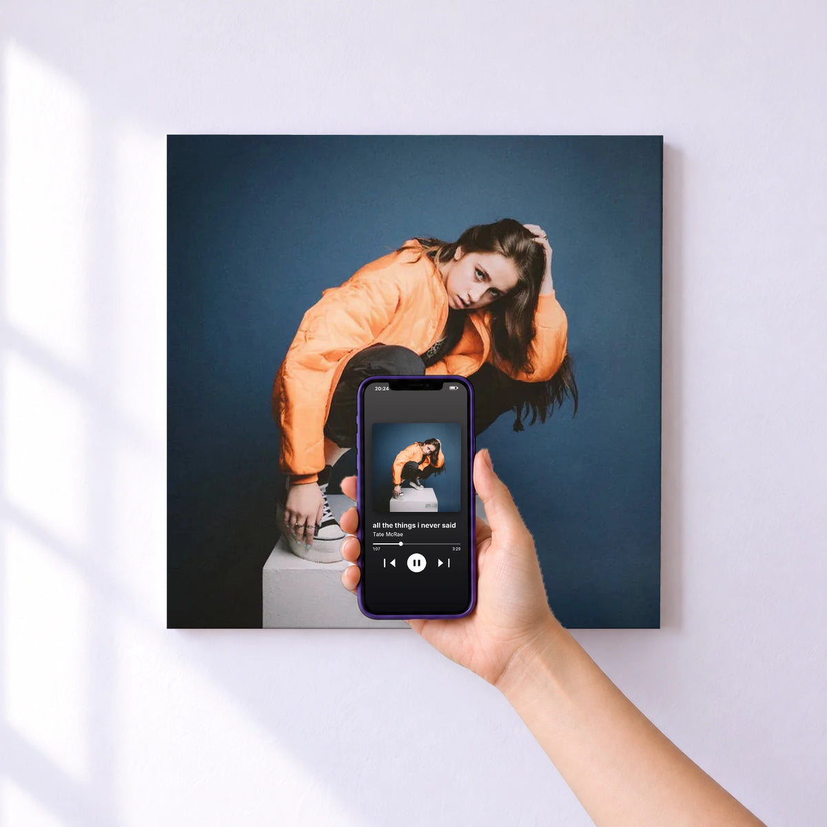Affiche connectée all the things i never said de Tate McRae au mur : l'album se lance en approchant le téléphone