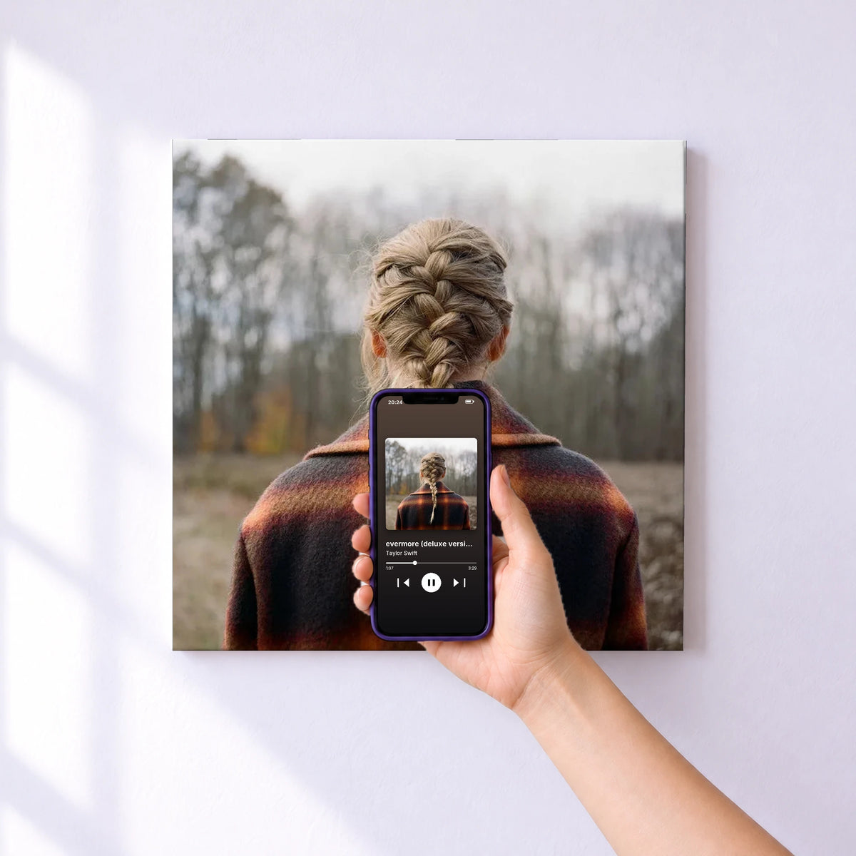 Affiche connectée evermore (deluxe version) de Taylor Swift au mur : l'album se lance en approchant le téléphone