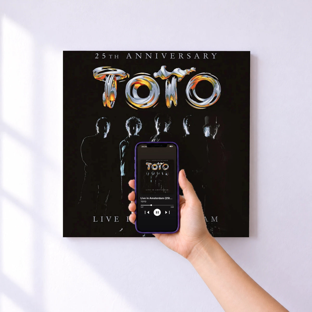Affiche connectée Live in Amsterdam (25th Anniversary) de TOTO au mur : l'album se lance en approchant le téléphone