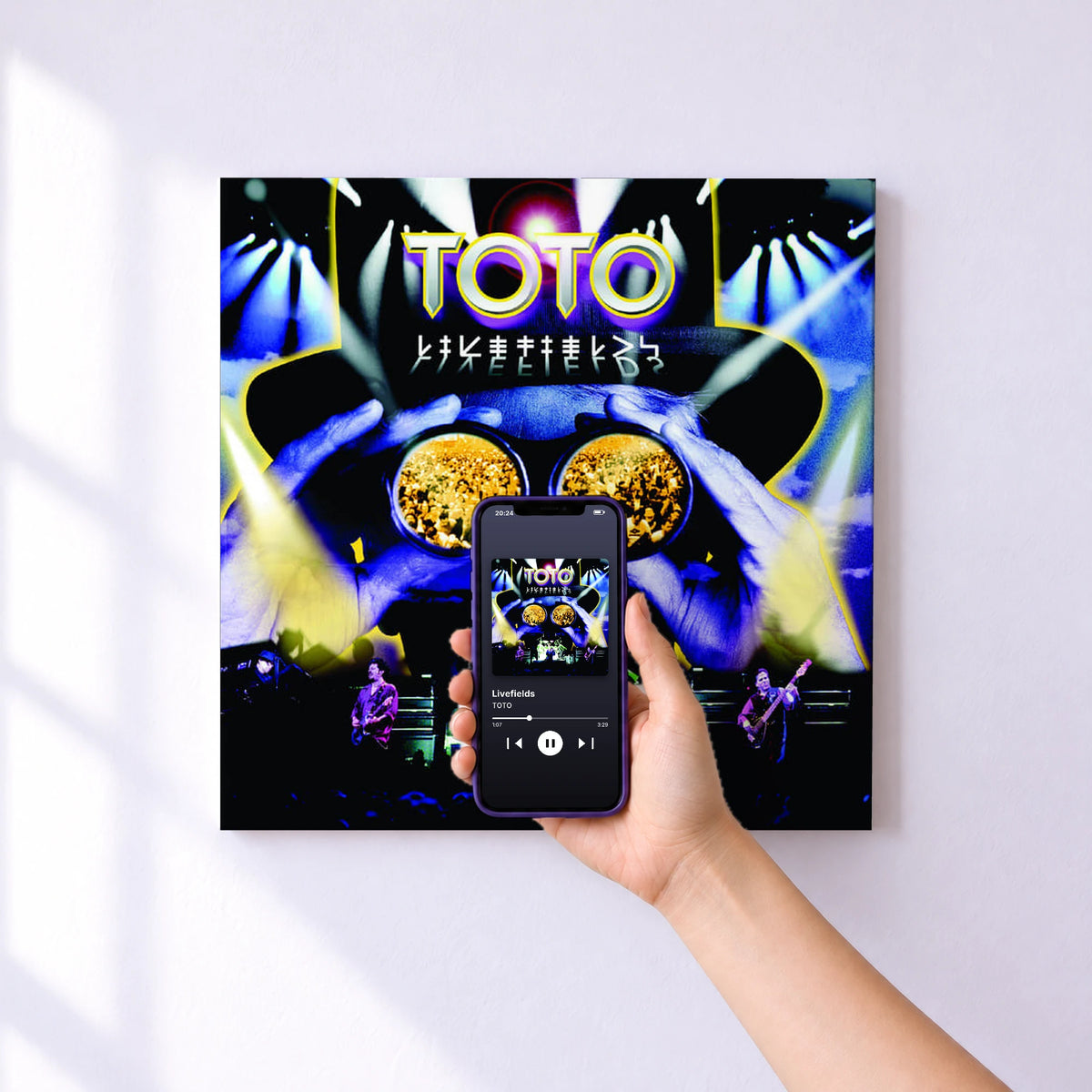 Affiche connectée Livefields de TOTO au mur : l'album se lance en approchant le téléphone