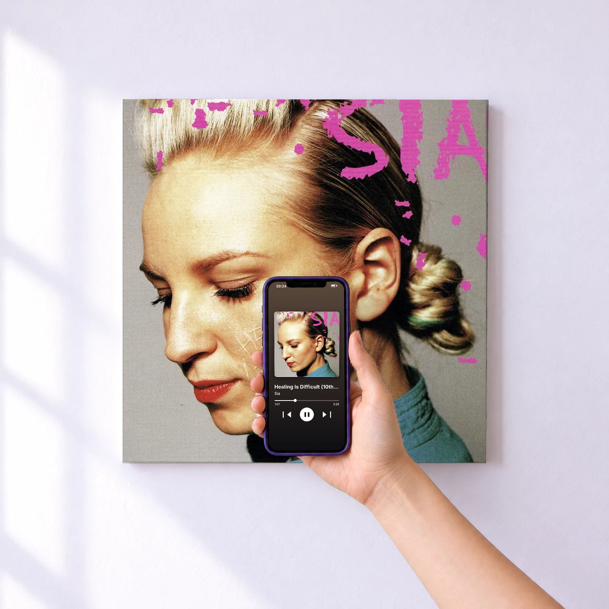 Affiche connectée Healing Is Difficult (10th Anniversary Edition) de Sia au mur : l'album se lance en approchant le téléphone